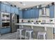 Bright kitchen with stainless steel appliances, blue cabinetry, and a large center island at 3865 W Stillwood Ln, Lake Mary, FL 32746