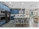 This open kitchen features blue cabinets, a center island, and a cozy breakfast nook with backyard views at 3865 W Stillwood Ln, Lake Mary, FL 32746