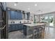 This open kitchen features blue cabinets, a center island, and a cozy breakfast nook with backyard views at 3865 W Stillwood Ln, Lake Mary, FL 32746