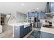 This open kitchen features blue cabinets, a center island, and modern stainless steel appliances at 3865 W Stillwood Ln, Lake Mary, FL 32746