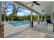Relaxing covered patio overlooking the pool, with stone pillars and modern ceiling fans at 3865 W Stillwood Ln, Lake Mary, FL 32746