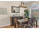 Dining area featuring a rustic buffet, a decorative mirror, modern lighting, and large windows at 445 Oakland Park Blvd, Port Orange, FL 32127