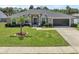 Charming single Gathering home featuring a well-manicured lawn, elegant landscaping, and an attached two-car garage at 445 Oakland Park Blvd, Port Orange, FL 32127
