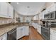 Spacious kitchen with white cabinets, granite countertops, stainless steel appliances and wood laminate floors at 445 Oakland Park Blvd, Port Orange, FL 32127