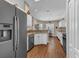 Bright kitchen featuring white cabinets, granite counters, stainless appliances, and wood-look floors at 445 Oakland Park Blvd, Port Orange, FL 32127