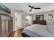 Bright main bedroom with wood laminate flooring, ceiling fan, and an ensuite bath and kitchen access at 445 Oakland Park Blvd, Port Orange, FL 32127