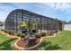 Backyard features an in-ground pool with screened enclosure and landscaped garden bed at 445 Oakland Park Blvd, Port Orange, FL 32127