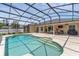 Sparkling pool with sun shelf inside a screened enclosure and connected to the home at 445 Oakland Park Blvd, Port Orange, FL 32127
