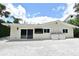 Exterior shot of the back of the home with neutral paint, sliding glass doors, and two storage units at 507 N Peninsula Ave, New Smyrna Beach, FL 32169