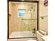 Tiled bathroom featuring a shower and tub combination with a glass door and dark hardware at 507 N Peninsula Ave, New Smyrna Beach, FL 32169
