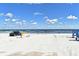 Sandy beach leads to the ocean, complemented by a parked SUV and lifeguard stand under sunny skies at 507 N Peninsula Ave, New Smyrna Beach, FL 32169