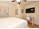 Bedroom featuring light hardwood floors, ceiling fan, a desk area, and a painting of sailboats at 507 N Peninsula Ave, New Smyrna Beach, FL 32169