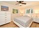 Bright bedroom featuring wood floors, ceiling fan, neutral walls, and dual windows with lush greenery at 507 N Peninsula Ave, New Smyrna Beach, FL 32169