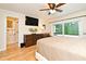 Bedroom with wood floors, large screen TV, dresser with decor, and glass door to the outside at 507 N Peninsula Ave, New Smyrna Beach, FL 32169