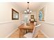 Charming dining room with wood floors, neutral decor, modern chandelier and an exit to the backyard at 507 N Peninsula Ave, New Smyrna Beach, FL 32169