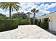 Expansive paver driveway with lush palm trees enhancing the home's tropical setting at 507 N Peninsula Ave, New Smyrna Beach, FL 32169