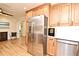 Kitchen area with stainless steel refrigerator, custom cabinets, hardwood floors and adjacent dining area at 507 N Peninsula Ave, New Smyrna Beach, FL 32169