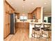 This stunning kitchen features natural wood cabinets, stainless steel appliances, and breakfast bar with trendy, comfortable bar stools at 507 N Peninsula Ave, New Smyrna Beach, FL 32169
