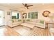 Bright living room with hardwood floors, large windows and neutral-colored sofas with a stylish ceiling fan at 507 N Peninsula Ave, New Smyrna Beach, FL 32169