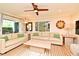 Well-lit living room with hardwood floors, neutral sofas and a large window creating a welcoming atmosphere at 507 N Peninsula Ave, New Smyrna Beach, FL 32169