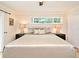Spacious main bedroom featuring wood floors, ceiling fan, neutral walls, and window with lush greenery at 507 N Peninsula Ave, New Smyrna Beach, FL 32169