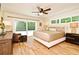 Main bedroom with hardwood floors, ceiling fan, sliding glass doors and large windows providing ample natural light at 507 N Peninsula Ave, New Smyrna Beach, FL 32169