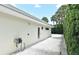 Side yard with white pebbles, featuring a well-maintained exterior and lush green hedges at 507 N Peninsula Ave, New Smyrna Beach, FL 32169
