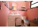 Pink bathroom with single sink vanity, toilet, and decorative wallpaper at 5262 Lescot Ln, Orlando, FL 32811