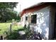 Exterior view of a brick house with fenced yard and overgrown grass at 5262 Lescot Ln, Orlando, FL 32811