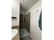 Bathroom showing tiled shower with glass door, granite vanity, and door at 626 Old Pine Ct, Sanford, FL 32773