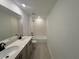Bathroom with dual sinks, quartz countertop, and tub with tile surround at 710 Junonia Blvd, New Smyrna Beach, FL 32168
