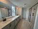 Modern bathroom featuring double sinks, long vanity, and glass-enclosed shower with black trim at 710 Junonia Blvd, New Smyrna Beach, FL 32168