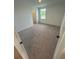 Bright bedroom featuring a large window for natural light and neutral carpeting at 710 Junonia Blvd, New Smyrna Beach, FL 32168