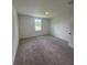 Well-lit bedroom featuring neutral carpeting and a bright window at 710 Junonia Blvd, New Smyrna Beach, FL 32168