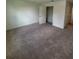 Well-lit bedroom featuring neutral carpeting and access to closet at 710 Junonia Blvd, New Smyrna Beach, FL 32168