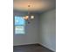Dining area featuring a modern chandelier, large window, and fresh neutral paint at 710 Junonia Blvd, New Smyrna Beach, FL 32168