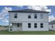 Rear exterior of a two-story home featuring vinyl siding and ample windows for lots of natural light at 710 Junonia Blvd, New Smyrna Beach, FL 32168