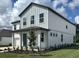 Beautiful two-story home with inviting covered porch, gray siding, and lush green lawn at 710 Junonia Blvd, New Smyrna Beach, FL 32168