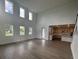 Bright, open-concept living room featuring tall windows and seamless flow into kitchen at 710 Junonia Blvd, New Smyrna Beach, FL 32168