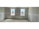 An unfinished room under construction featuring dual windows for ample natural light and smooth drywall at 710 Junonia Blvd, New Smyrna Beach, FL 32168
