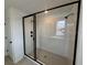 Contemporary shower featuring glass enclosure with black trim and tile walls at 710 Junonia Blvd, New Smyrna Beach, FL 32168