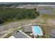 Scenic aerial view showcasing a community pool near a wooded area, adjacent to homes and a parking lot at 715 Auburn Grove Ct, Auburndale, FL 33823