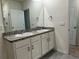 Bathroom featuring double sinks with granite counters and white cabinetry at 715 Auburn Grove Ct, Auburndale, FL 33823