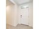 Entryway with light tile floor and white painted door with glass transom at 715 Auburn Grove Ct, Auburndale, FL 33823