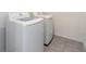 Modern laundry area showcasing a new washer and dryer with sleek tile flooring at 715 Auburn Grove Ct, Auburndale, FL 33823
