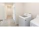 Convenient laundry area with a new washer and dryer adjacent to a hallway with tile flooring at 715 Auburn Grove Ct, Auburndale, FL 33823