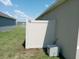 A side yard area with beige vinyl fence and A/C unit at 715 Auburn Grove Ct, Auburndale, FL 33823