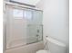 Bathroom shower-tub combo with glass sliding door and a window with blinds at 7263 Winding Lake Cir, Oviedo, FL 32765