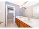 Bathroom with double sink vanity, large mirror, and shower/tub combo behind open door at 7263 Winding Lake Cir, Oviedo, FL 32765