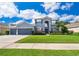Charming two-story home featuring a manicured lawn and lush landscaping, showcasing curb appeal at 7263 Winding Lake Cir, Oviedo, FL 32765